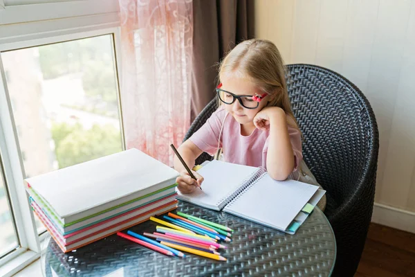 Cute little caucasian girl doing homework and writing a paper. Kid enjoy learning with happiness at home. Clever,Education and smart learning concept