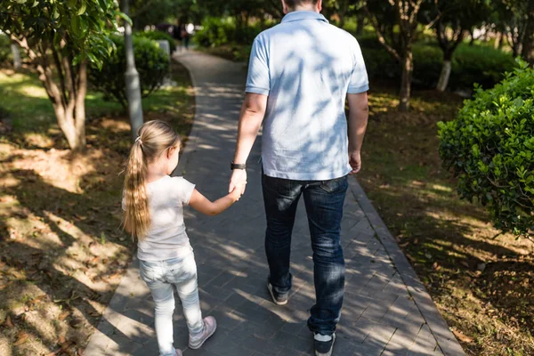 Papa Holding handen dochter met liefde en wandelen in het Park. Familieconcept — Stockfoto