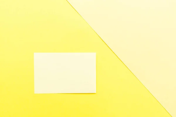 黄色的纸放在黄色的背景上. 顶部视图。 模拟，复制空间，简约主义 — 图库照片