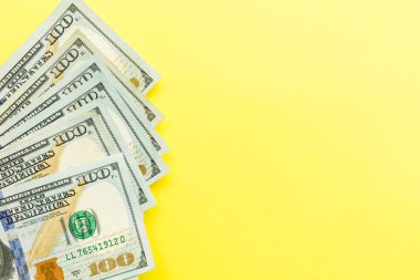 100 dolarlık banknotlar nakit sarı arka planda yatıyor. Finansal ve iş kavramı. Düz yatıyordu, mockup, havai, minimalizm