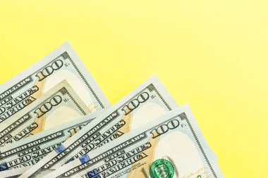 100 dolarlık banknotlar nakit sarı arka planda yatıyor. Finansal ve iş kavramı. Düz yatıyordu, mockup, havai, minimalizm