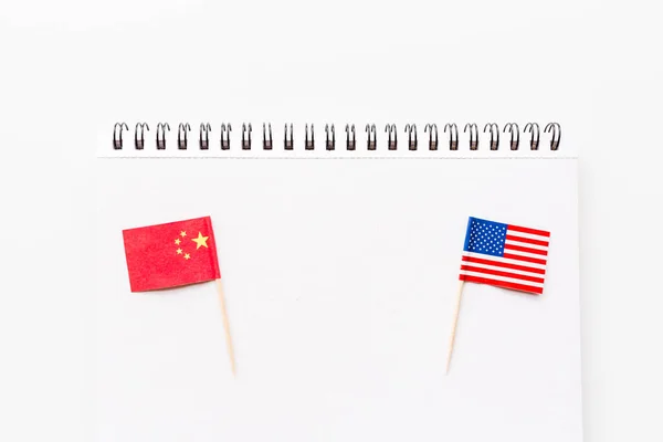 Creative top view flat lay of China and USA flag, mockup and copy space on white background in minimal style. Concept of trade war between USA and China