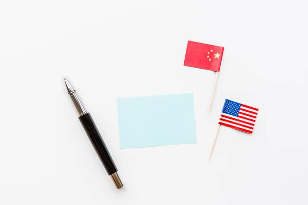 Creative top view flat lay of China and USA flag, pen, mockup and copy space on white background in minimal style. Concept of trade war between USA and China