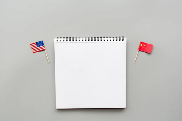 Vue de dessus créative à plat des drapeaux des États-Unis et de la Chine, maquette et espace de copie sur fond gris dans un style minimal. Concept de guerre commerciale entre les USA et la Chine — Photo