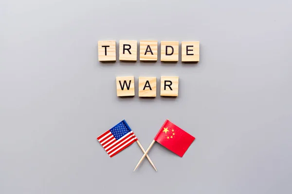Creative top view flat lay of China and USA flags, mockup and copy space on gray background in minimal style. Concept of trade war between USA and China
