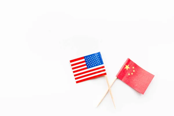 創造的なトップビューのフラットレイアメリカと中国のフラグ、モックアップと最小限のスタイルで白い背景にスペースをコピーします。アメリカと中国の貿易戦争の概念 — ストック写真