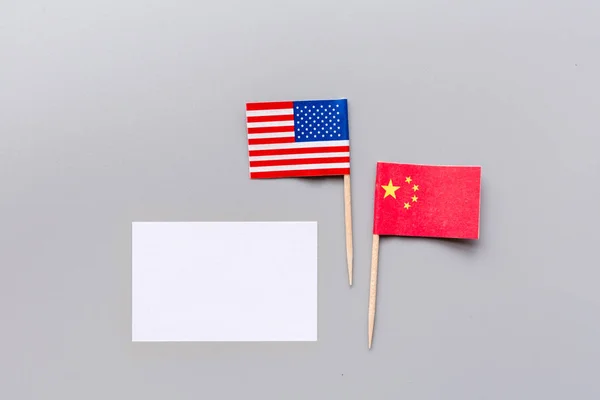 創造的なトップビューのフラットレイ中国と米国のフラグ、最小限のスタイルでグレーの背景にモックアップとコピースペース。アメリカと中国の貿易戦争の概念 — ストック写真
