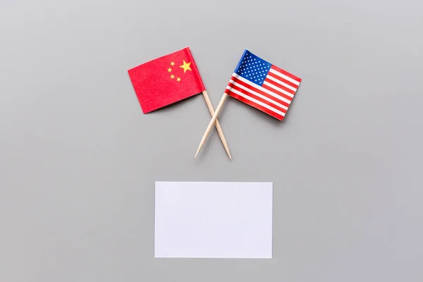 創造的なトップビューのフラットレイ中国と米国のフラグ、最小限のスタイルでグレーの背景にモックアップとコピースペース。アメリカと中国の貿易戦争の概念 — ストック写真