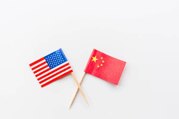 Creative top view flat lay of USA and China flags, mockup and copy space on white background in minimal style. Concept of trade war between USA and China