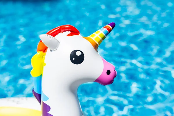 Unicórnio branco colorido inflável na piscina. Hora de verão na piscina com brinquedos de plástico. Verão férias, Relaxamento e diversão conceito — Fotografia de Stock