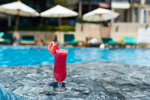 Copo fresco de bebida smoothie melancia de pé perto da piscina conceito de férias, relaxamento, bebida saudável — Fotografia de Stock