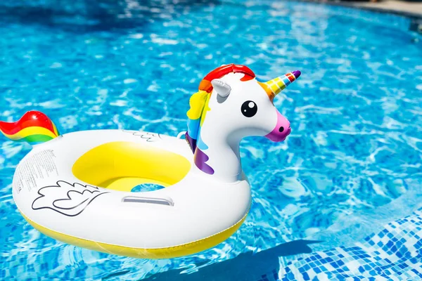 Unicórnio branco colorido inflável na piscina. Hora de verão na piscina com brinquedos de plástico. Verão férias, Relaxamento e diversão conceito — Fotografia de Stock