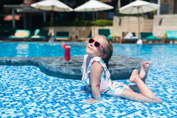 Menina bonito em maiô relaxante na piscina no hotel resort. Verão férias, relaxamento, conceito de viagem — Fotografia de Stock