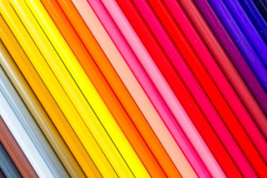 Pastel turuncu kağıt üzerinde yatan birçok boya kalemleri ile parlak ve renkli arka plan. Üst görünüm, düz yatıyordu, mockup, havai, kopyalama alanı. Eğitim ve okul kavramına geri dönüş