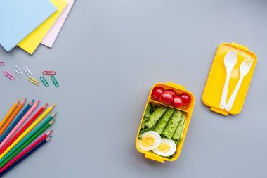 Okul malzemeleri ve sandviç ve sebze ile öğle yemeği kutusu. Okula dönüyoruz. Sağlıklı beslenme alışkanlıkları kavramı-ücretsiz metin alanı ile arka plan düzeni. Düz yatıyordu kompozisyon, mockup, üst görünüm