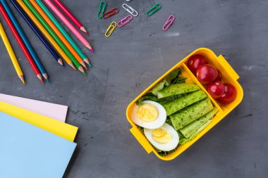 Okul malzemeleri ve sandviç ve sebze ile öğle yemeği kutusu. Okula dönüyoruz. Sağlıklı beslenme alışkanlıkları kavramı-ücretsiz metin alanı ile arka plan düzeni. Düz yatıyordu kompozisyon, mockup, üst görünüm