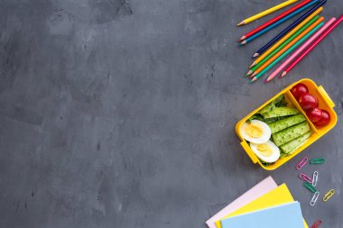 Okul malzemeleri ve sandviç ve sebze ile öğle yemeği kutusu. Okula dönüyoruz. Sağlıklı beslenme alışkanlıkları kavramı-ücretsiz metin alanı ile arka plan düzeni. Düz yatıyordu kompozisyon, mockup, üst görünüm