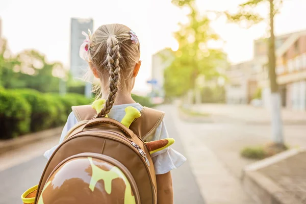Gyerek lány tanuló hátulról gyaloglás vissza otthonra tanulás után tanulmányi iskolában egyedül schoolbag, óvodai és óvoda oktatás fogalmát. Az ősz első napja — Stock Fotó