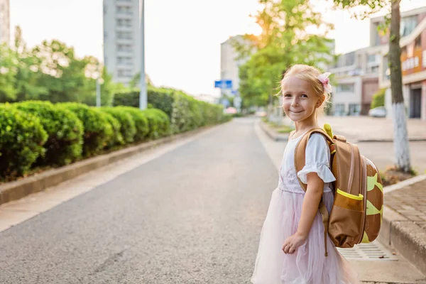 Gyerek lány tanuló hátulról gyaloglás vissza otthonra tanulás után tanulmányi iskolában egyedül schoolbag, óvodai és óvoda oktatás fogalmát. Az ősz első napja — Stock Fotó