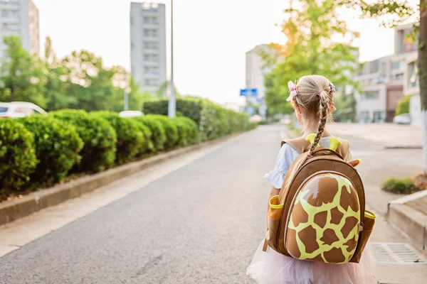 Gyerek lány tanuló hátulról gyaloglás vissza otthonra tanulás után tanulmányi iskolában egyedül schoolbag, óvodai és óvoda oktatás fogalmát. Az ősz első napja — Stock Fotó