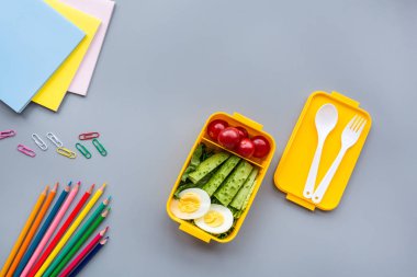 Okul malzemeleri ve sandviç ve sebze ile öğle yemeği kutusu. Okula dönüyoruz. Sağlıklı beslenme alışkanlıkları kavramı-ücretsiz metin alanı ile arka plan düzeni. Düz yatıyordu kompozisyon, mockup, üst görünüm