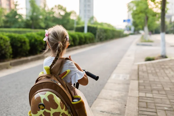 Gyerek lány tanuló hátulról gyaloglás vissza otthonra tanulás után tanulmányi iskolában egyedül schoolbag, óvodai és óvoda oktatás fogalmát. Az ősz első napja — Stock Fotó