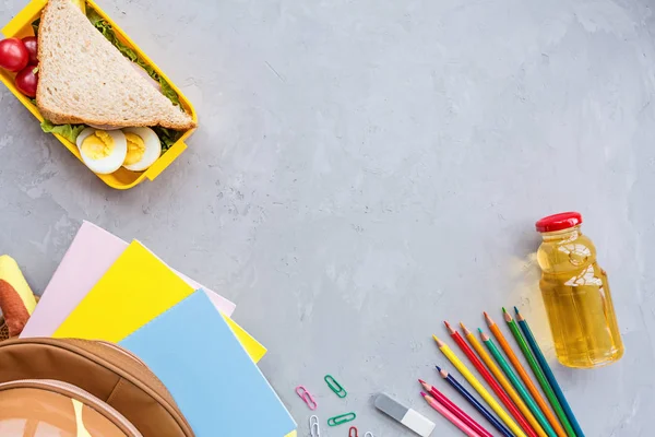 Okul malzemeleri ve sandviç ve sebze ile öğle yemeği kutusu. Okula dönüyoruz. Sağlıklı beslenme alışkanlıkları kavramı-ücretsiz metin alanı ile arka plan düzeni. Düz yatıyordu kompozisyon, mockup, üst görünüm