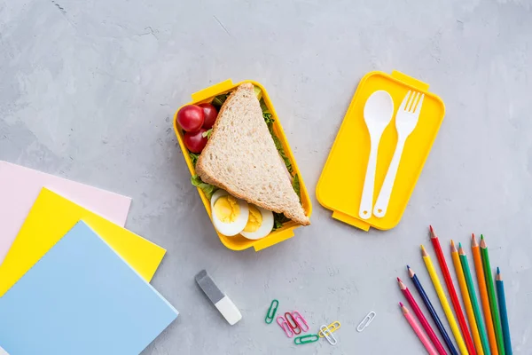 学用品とサンドイッチと野菜の弁当箱。学校に戻れ健康的な食習慣の概念 - フリーテキストスペースを持つ背景レイアウト。フラットレイコンポジション、モックアップ、トップビュー — ストック写真