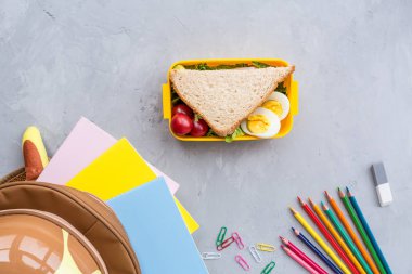 Okul malzemeleri ve sandviç ve sebze ile öğle yemeği kutusu. Okula dönüyoruz. Sağlıklı beslenme alışkanlıkları kavramı-ücretsiz metin alanı ile arka plan düzeni. Düz yatıyordu kompozisyon, mockup, üst görünüm