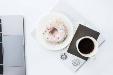 Düz yatıyordu, üst görünüm ofis masa masası çerçevesi. Çalışma alanı dizüstü bilgisayar, kalem, Notebook, kahve bardağı ve çörek beyaz arka planda. Yükü. 