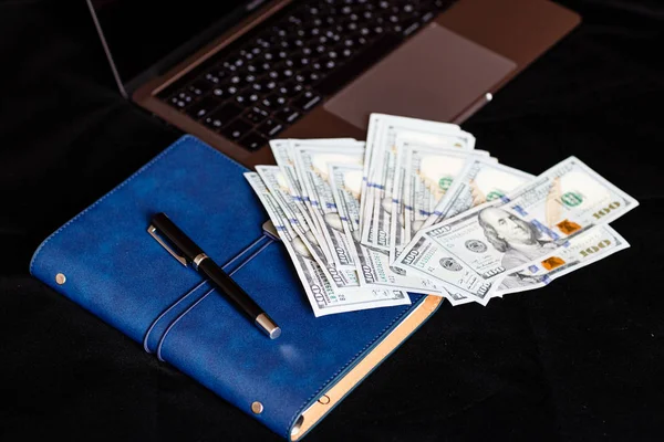 Desktop flatlay: laptop, Notatnik, pióro i pieniądz pieniężny leżący na czarnym tle. Koncepcja finansów, pracy i biznesu — Zdjęcie stockowe
