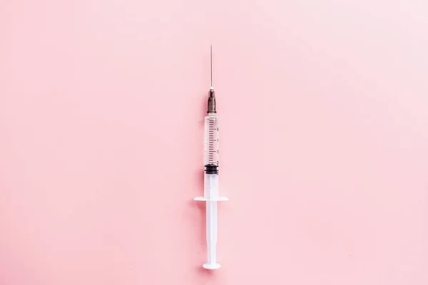 Jeringa médica sobre fondo rosa, salud y concepto de vacunación. Colocación plana, maqueta, techo, vista superior y espacio de copia . — Foto de Stock