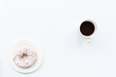 kopya alanı ile çörek ve siyah kahve. Beyaz masada bir plaka üzerinde donut ile siyah kahve fincan, üst görünüm, düz yatıyordu. Lezzetli kahvaltı.