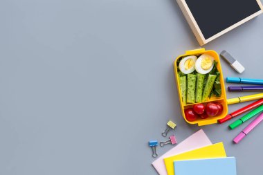 Okul malzemeleri ve sandviç ve sebze ile öğle yemeği kutusu. Okula dönüyoruz. Sağlıklı beslenme alışkanlıkları kavramı-ücretsiz metin alanı ile arka plan düzeni. Düz yatıyordu kompozisyon, mockup, üst görünüm