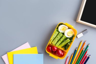 Okul malzemeleri ve sandviç ve sebze ile öğle yemeği kutusu. Okula dönüyoruz. Sağlıklı beslenme alışkanlıkları kavramı-ücretsiz metin alanı ile arka plan düzeni. Düz yatıyordu kompozisyon, mockup, üst görünüm