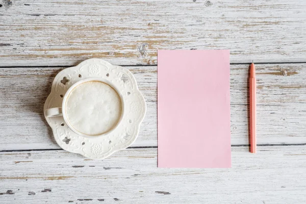 Taza de café de la mañana para el desayuno, papel rosa en blanco sobre mesa de madera blanca, vista superior, estilo laico plano. Escritorio de mujer. Burla, gastos generales — Foto de Stock