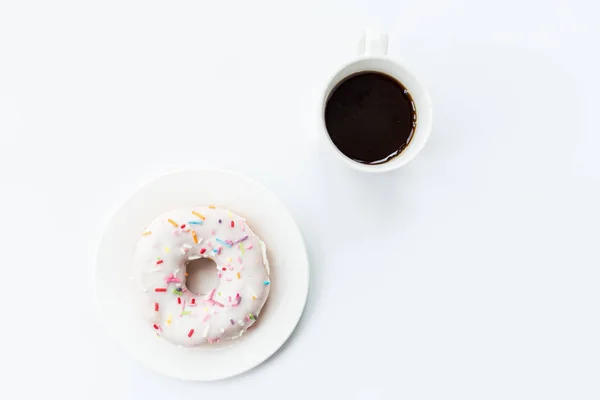 Dona y café negro con espacio para copiar. Taza de café negro con rosquilla en un plato en la mesa blanca, vista superior, puesta plana. Delicioso desayuno . —  Fotos de Stock