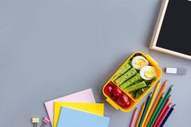 Okul malzemeleri ve sandviç ve sebze ile öğle yemeği kutusu. Okula dönüyoruz. Sağlıklı beslenme alışkanlıkları kavramı-ücretsiz metin alanı ile arka plan düzeni. Düz yatıyordu kompozisyon, mockup, üst görünüm