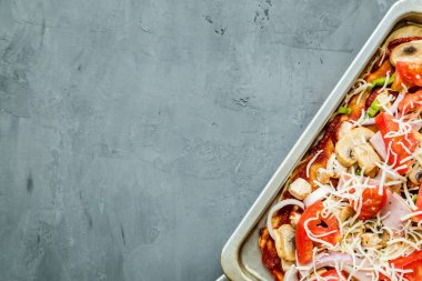 Mantar ile lezzetli ev yapımı pizza, domates, tavuk, gri beton arka planda peynir. Sıcak pizzanın üst görünümü. Metin için kopya alanı ile. Düz yatıyordu. Ek yük, mockup