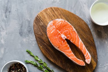 Koyu taş arka plan üzerinde baharat ile taze çiğ somon balık biftek. Balık, üst görünüm, düz yatıyordu, mockup, havai yapılmış Yaratıcı düzeni. Sağlıklı gıda kavramı