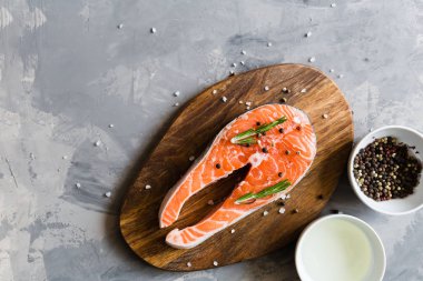 Koyu taş arka plan üzerinde baharat ile taze çiğ somon balık biftek. Balık, üst görünüm, düz yatıyordu, mockup, havai yapılmış Yaratıcı düzeni. Sağlıklı gıda kavramı