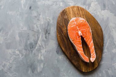 Koyu taş arka plan üzerinde taze çiğ somon balık biftek. Balık, üst görünüm, düz yatıyordu, mockup, havai yapılmış Yaratıcı düzeni. Sağlıklı gıda kavramı