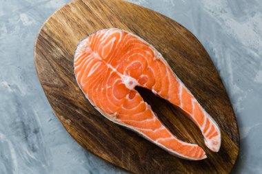 Koyu taş arka plan üzerinde taze çiğ somon balık biftek. Balık, üst görünüm, düz yatıyordu, mockup, havai yapılmış Yaratıcı düzeni. Sağlıklı gıda kavramı