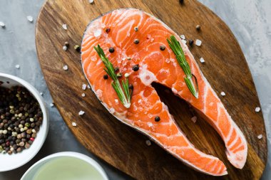 Koyu taş arka plan üzerinde baharat ile taze çiğ somon balık biftek. Balık, üst görünüm, düz yatıyordu, mockup, havai yapılmış Yaratıcı düzeni. Sağlıklı gıda kavramı