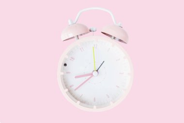 Pembe pastel arka planda izole edilmiş klasik alarm saati. Dinlenme saatleri güzel. Düz konum, üst görünüm, kopyalama alanı, model, genel giderler