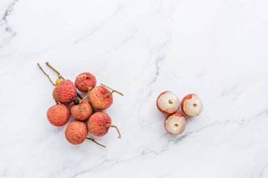 Beyaz mermer arka planda taze liçi, yaratıcı gıda konsepti, tropikal meyve düzlüğü. Metin için yer. Kopyalama alanını kapat, model. Sağlıklı gıda konsepti