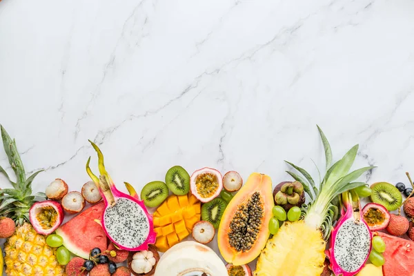 Taze egzotik meyve ve tropikal palmiye beyaz mermer arka plan üzerinde yaprakları - papaya, mango, ananas, tutku meyve, ejderha meyve, kavun. Mockup, düz yatıyordu, havai. Üstte görüntü.