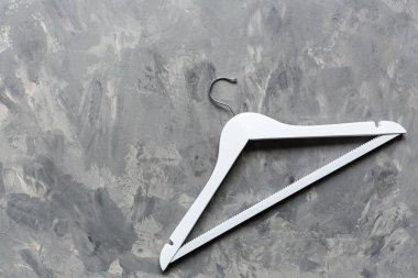 Gri beton arka planda beyaz ahşap askı. Moda kadınsı blog satış mağazası tanıtım tasarımı alışveriş konsepti. Düz yatış, üst görünüm, model, genel giderler