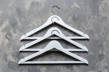 Gri beton arka planda beyaz ahşap askı. Moda kadınsı blog satış mağazası tanıtım tasarımı alışveriş konsepti. Düz yatış, üst görünüm, model, genel giderler