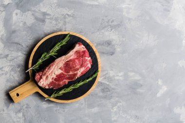 Biberiye ve baharatlar ile kesme tahtası üzerinde çiğ et sığır eti. Üst görünüm, düz yatıyordu, mockup, kopyalama alanı. Gıda konsepti